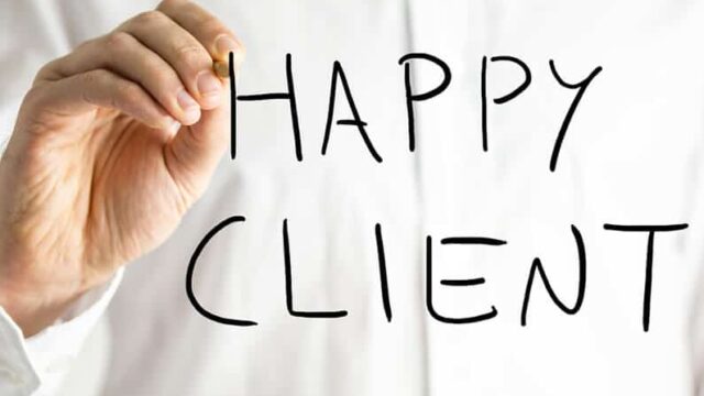 Happy Client written on a glass surface by a businessman