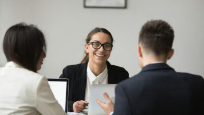 Smiling businesswoman talking with colleagues about CX reports